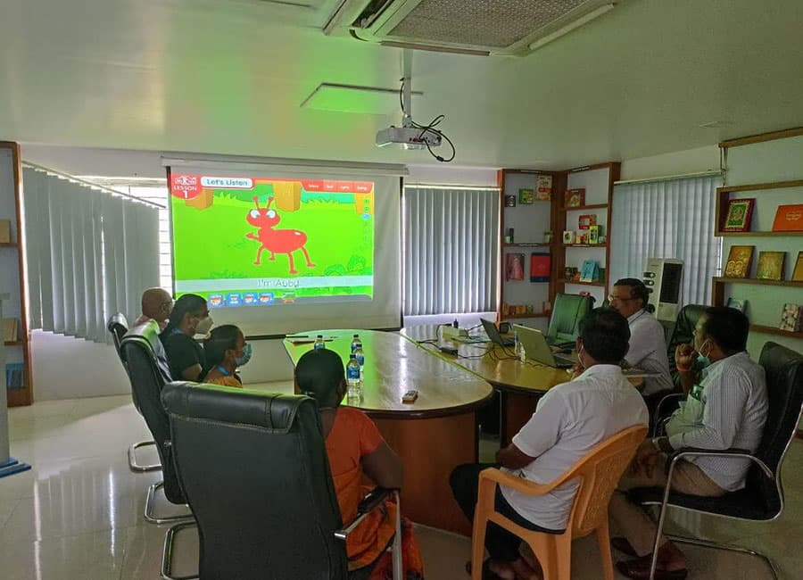 Teachers watching a colourful lesson on a projector