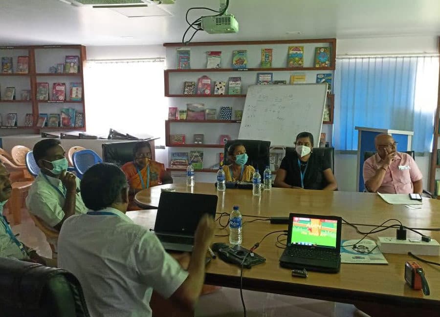 Group meeting around a table with laptops